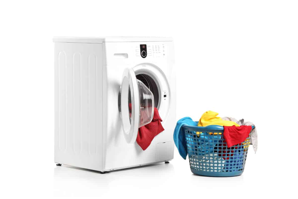 A washing machine and full laundry bin isolated on white background