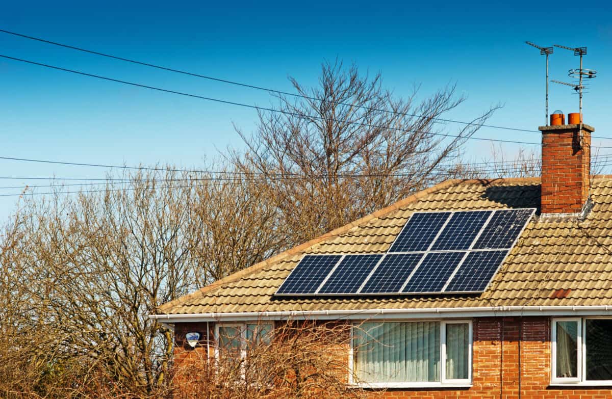 Solar panels on the roof of a house. It's winter, but the sky is bright so the panels will still be generating useful amounts of electricity.