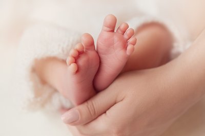 New baby’s feet held by mother