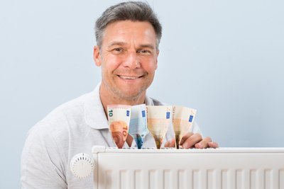 Man with euros beside a radiator