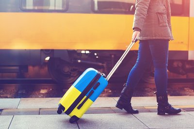 Person pulling suitcase with Ukraine flag