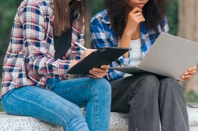 Students chatting and holding computers