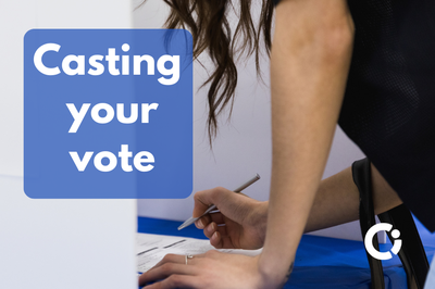 Woman holds pencil in her hand as she completes the ballot at the polling station