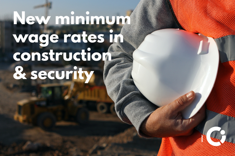 Construction worker in orange jacket holds a white safety helmet. Text reads: "New minimum wage rates in construction & security"