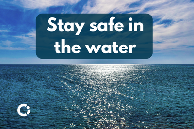 Sea water shines in the sun. Text reads: "Stay safe in the water"